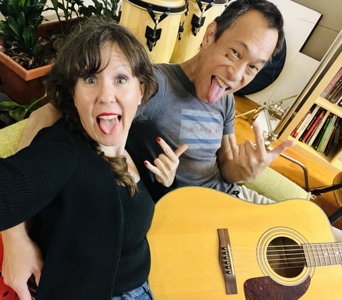 Elizabeth and Jeff making rock-and-roll faces behind an acoustic guitar